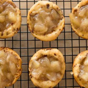 Apple Pie Cups with a cinnamon roll crust on a wire rack after baking