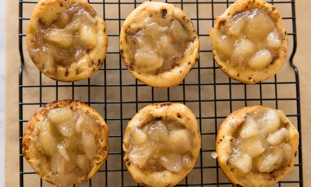 Apple Pie Cups with a cinnamon roll crust on a wire rack after baking