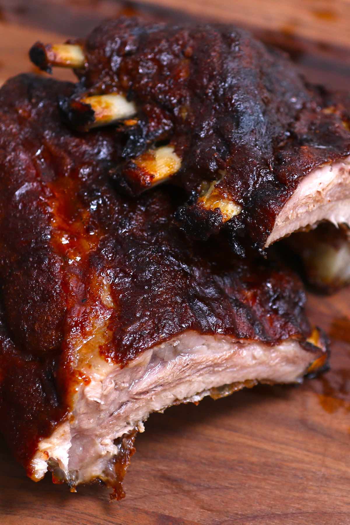 Cross-sectional closeup of 3 2 1 ribs showing juicy, tender meat and a set sauce on the outside