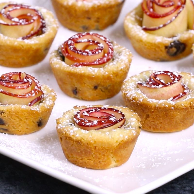 This photo shows apple rose cookies dusted with powdered sugar and served on a platter