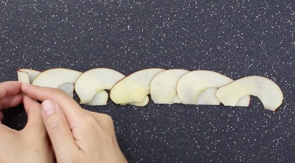 This photo shows how to roll thin apple slices together to make apple roses