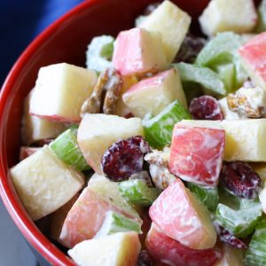 Crunchy apple salad in a serving bowl made with Fuji apples, walnuts, celery and cranberries