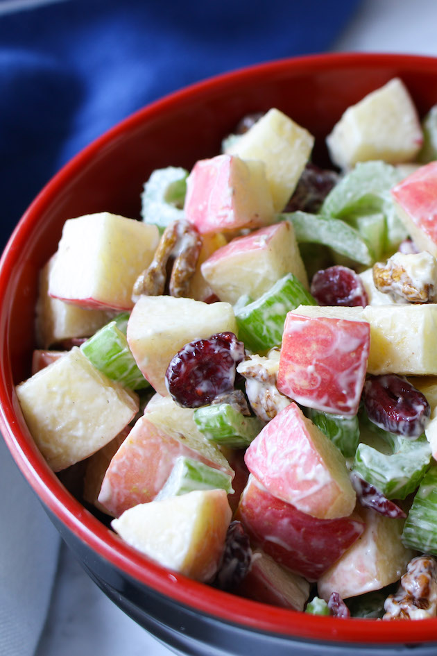 Delicious apple salad in a serving bowl made with Fuji apples, walnuts, celery and cranberries