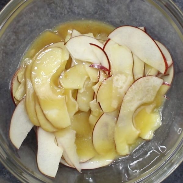 This is a photo of apple slices with a brown sugar, butter and lemon juice mixture to prevent browning when making apple roses