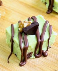 Pieces of avocado fudge with crushed nuts and melted chocolate drizzle