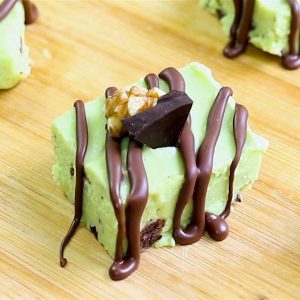 Pieces of avocado fudge with crushed nuts and melted chocolate drizzle
