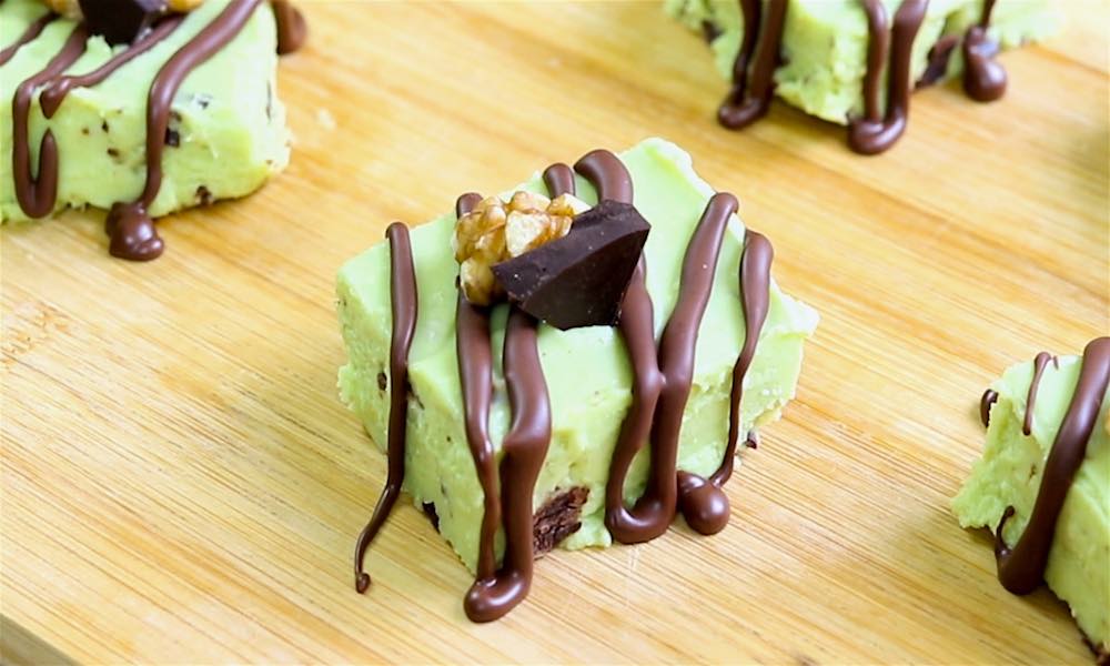 Pieces of avocado fudge served with crushed nuts and chocolate drizzle