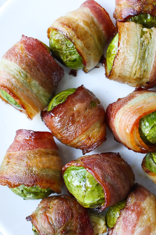 Overhead view of Bacon Wrapped Brussel Sprouts on a serving platter showing the beautiful color contrast of crispy bacon and green Brussel sprouts