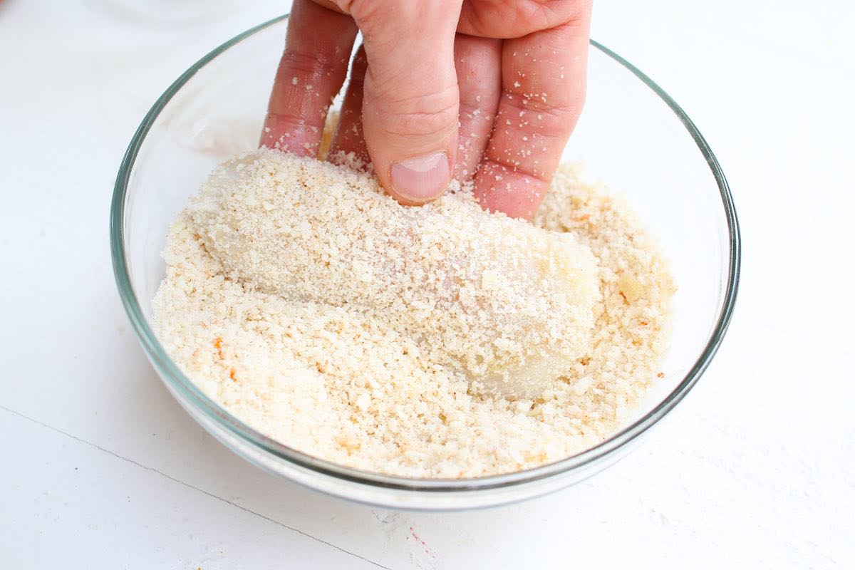 Breading haddock fillets by dredging in breadcrumbs or crushed Ritz crackers