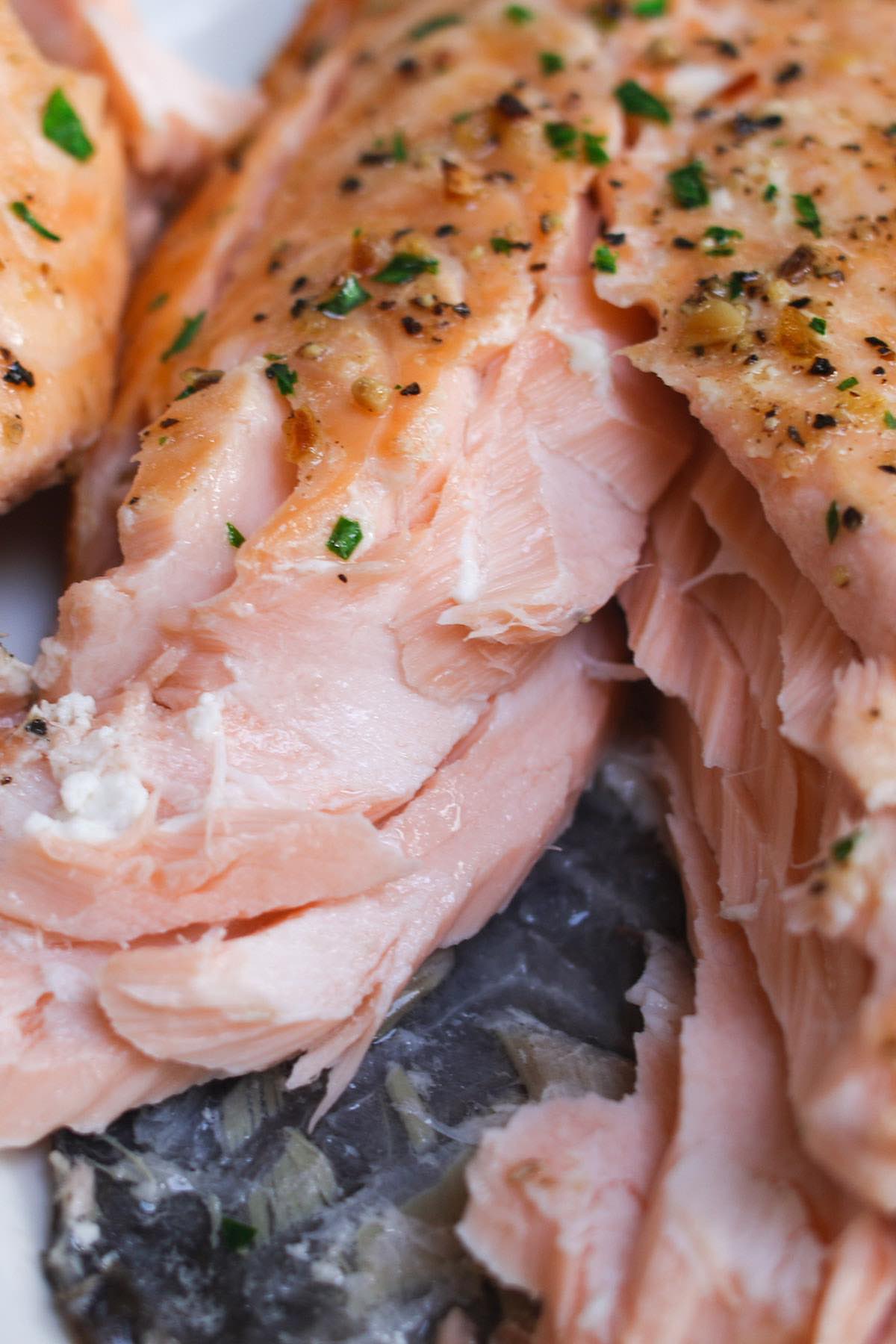 Closeup of baked salmon showing a moist texture and nice flaking when perfectly cooked