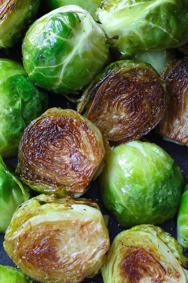 Brussel sprouts roasted to crispy perfection on a black sheet pan