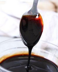 Balsamic reduction coating a serving spoon showing it's glaze-like consistency and rich deep color. This versatile condiment add a burst of flavor to meats, seafood, salads, fruits and even ice cream!
