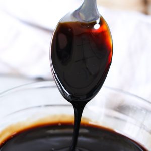 Balsamic reduction coating a serving spoon showing it's glaze-like consistency and rich deep color. This versatile condiment add a burst of flavor to meats, seafood, salads, fruits and even ice cream!