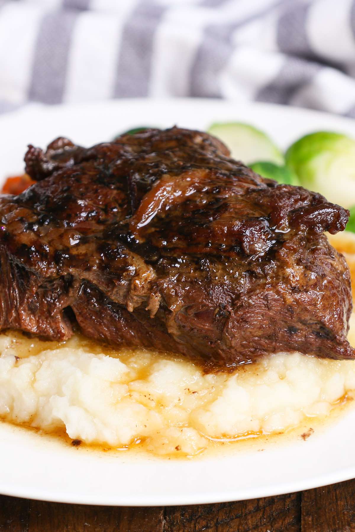 Braised beef on a bed of mashed potatoes with Brussel sprouts