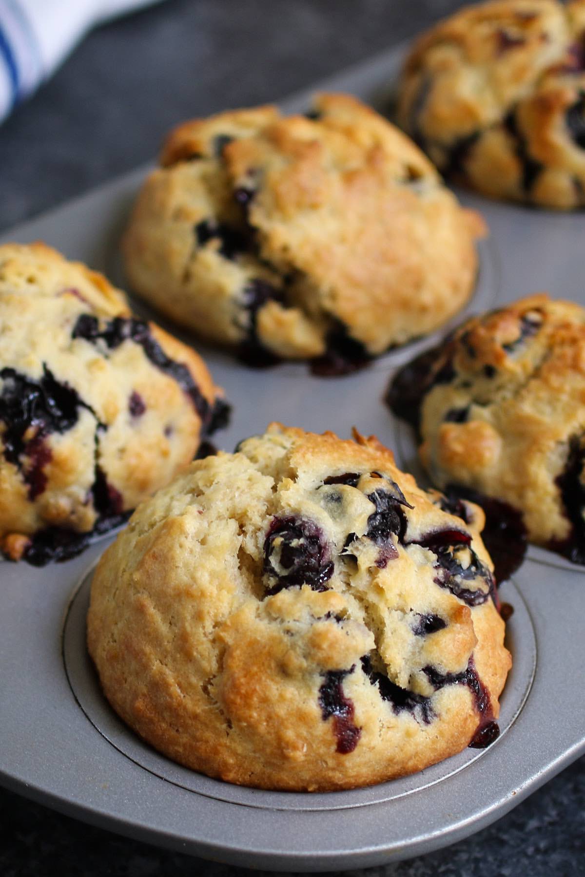Healthy Blueberry Muffins with golden tops in a muffin pan after baking
