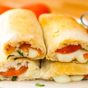 This Calzone Recipe will take your Italian favorite to a new level - loaded with sausage, peperoni, mozzarella, ricotta, Parmesan cheese and vegetables wrapped with soft and fluffy calzone dough. These cheesy Calzones make perfect weeknight dinner. Tipbuzz.com #Calzones #CalzoneRecipe