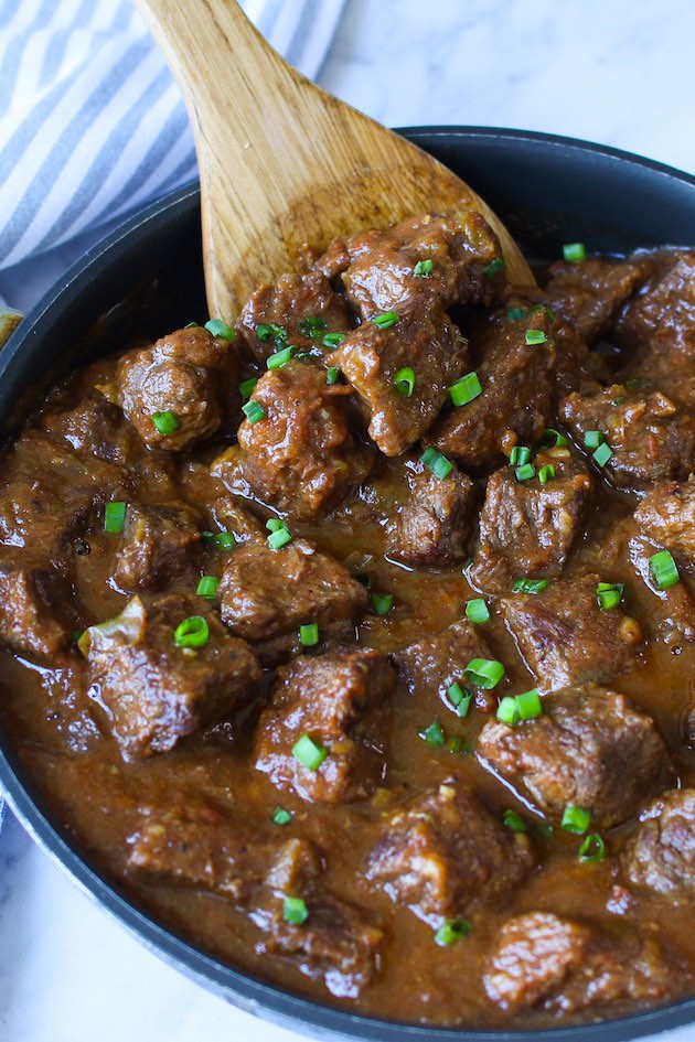 This recipe for carne guisada features chunks of chuck steak simmered with onions, garlic, green bell pepper, tomatoes, cumin, salt and pepper