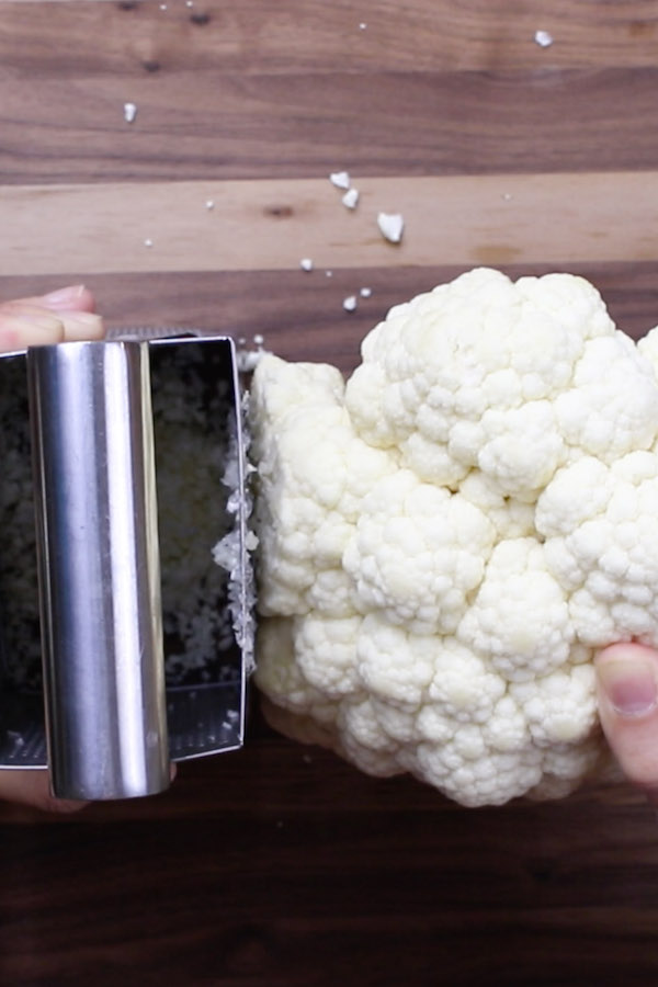 Grating cauliflower using a box grater when making cauliflower rice