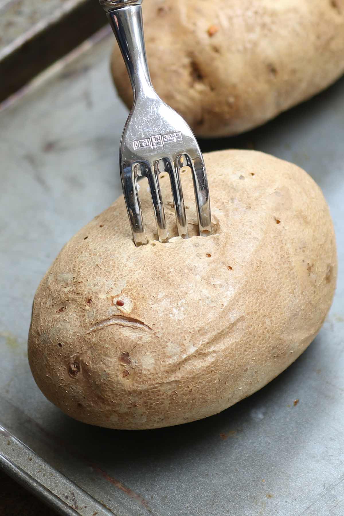 Checking how long to bake a potato by inserting a fork into the center 