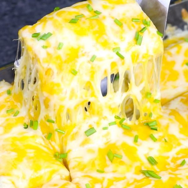 Cheesy Burrito Casserole being served from a baking dish with cheese strings