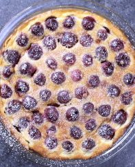 Overhead view of a freshly baked cherry clafoutis dusted with powdered sugar
