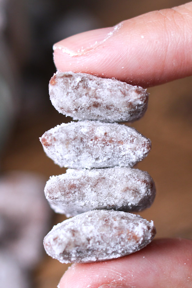 Closeup of pieces of Muddy Buddies made with Rice Chex cereal, chocolate, peanut butter and coated in powdered sugar