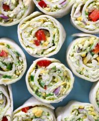 Chicken Avocado Salad Roll Ups – Ready in 15 minutes and it’s a guaranteed hit with family and friends. All you need is some simple ingredients: Shredded chicken, avocado, plain yogurt, lime juice, red onion, red bell pepper, green onion, cheddar cheese, parsley and flour tortillas. So yummy! Perfect for a summer time party or a picnic. Quick and easy recipe. Lunch or side dish. Video recipe. | Tipbuzz.com