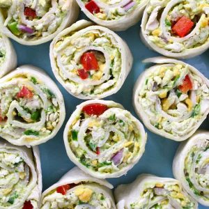 Chicken Avocado Salad Roll Ups – Ready in 15 minutes and it’s a guaranteed hit with family and friends. All you need is some simple ingredients: Shredded chicken, avocado, plain yogurt, lime juice, red onion, red bell pepper, green onion, cheddar cheese, parsley and flour tortillas. So yummy! Perfect for a summer time party or a picnic. Quick and easy recipe. Lunch or side dish. Video recipe. | Tipbuzz.com