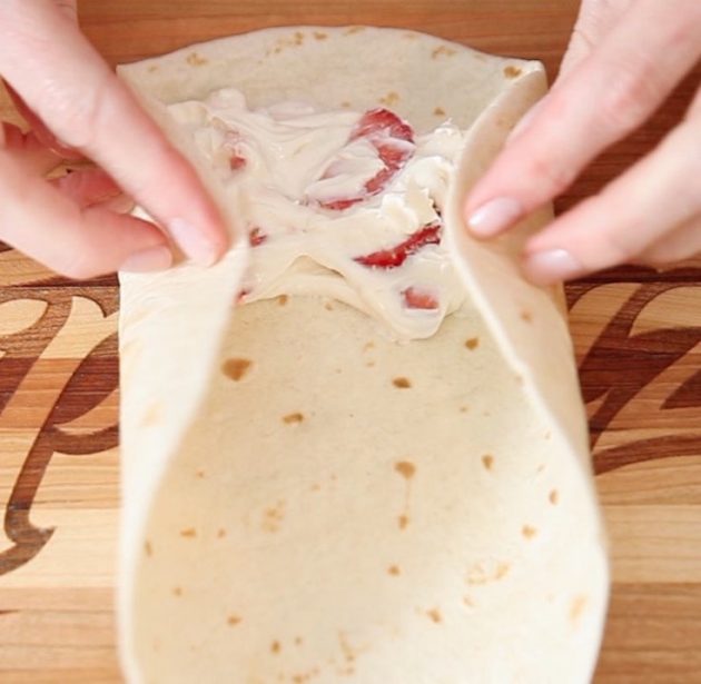 Folding the cheesecake filling into a flour tortilla 