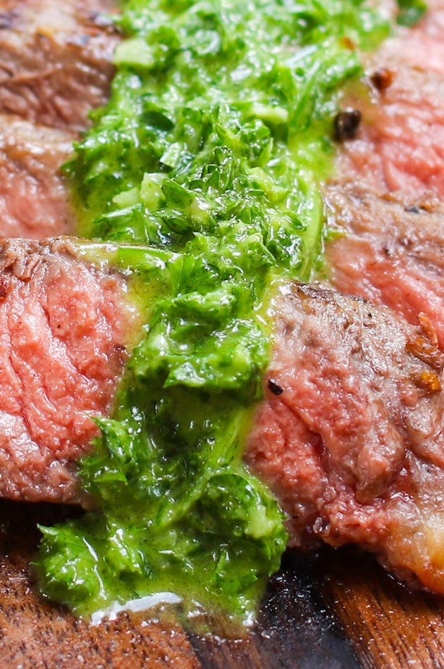 Spoon chimichurri sauce onto the pan-seared rib-eye steak