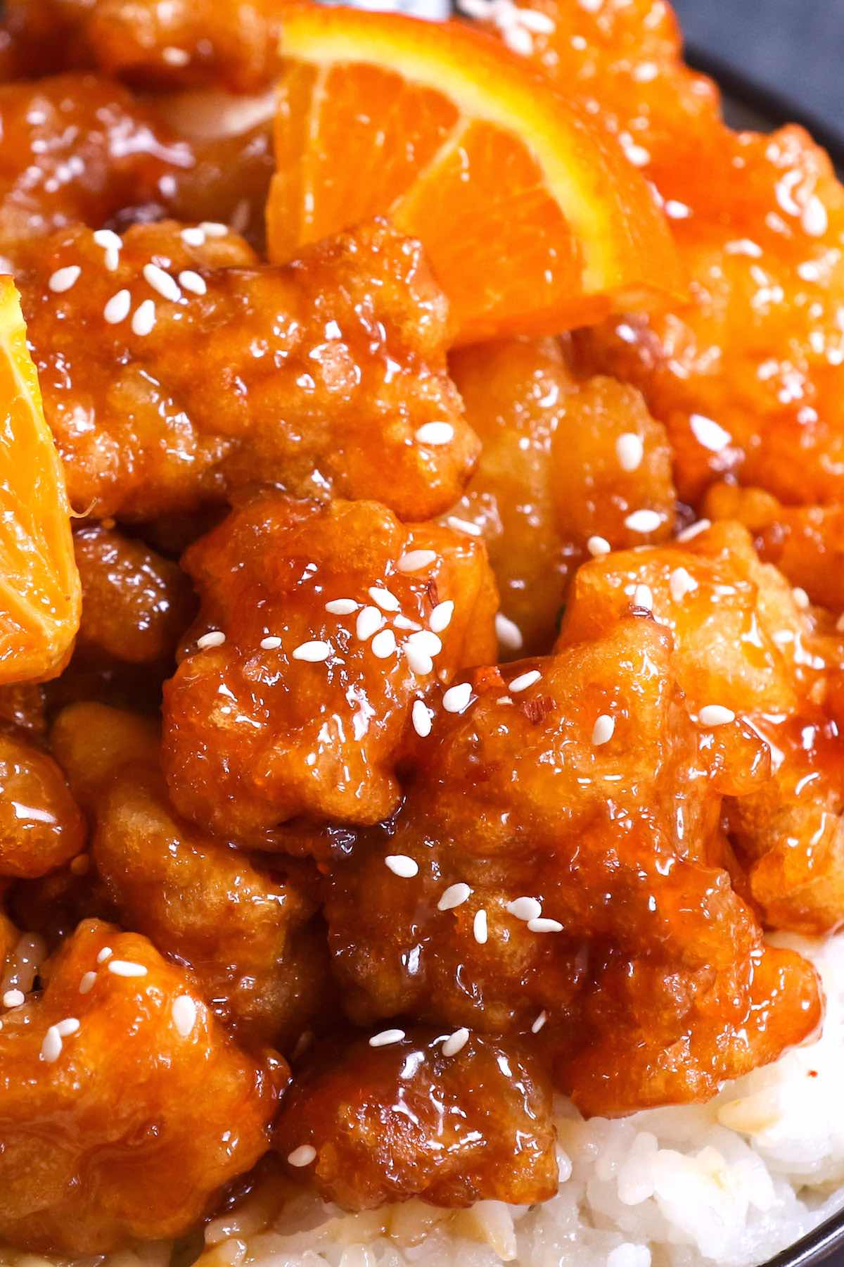 Closeup of orange chicken garnished with sesame seeds