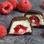 Choc Covered Cheesecake Rasp Raspberries Stuffed in smooth and creamy mini cheesecake bites, and then covered by chocolate. The ice cube tray makes it so easy and fun to make! All you need is a few simple ingredients: raspberries, chocolate, cream cheese, sugar, vanilla and whipped cream. An easy recipe that makes a great finger food dessert for parties, brunch, Mother’s Day or as an afternoon snack! Party food, no bake, party dessert recipes. Video recipe. | Tipbuzz.com