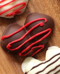 Chocolate Covered Strawberry Hearts – The easiest and most beautiful homemade gifts around! It takes 30 minutes to make and taste absolutely heavenly. Fresh and juicy strawberries are cut in half, making the heart shapes, then covered with gourmet semisweet or white chocolate. Decorate them with red decorating gel and melted chocolate. Just 4 ingredients are all you need! So good! Quick and easy recipe, no bake dessert, valentine’s recipe, mother’s day recipe.