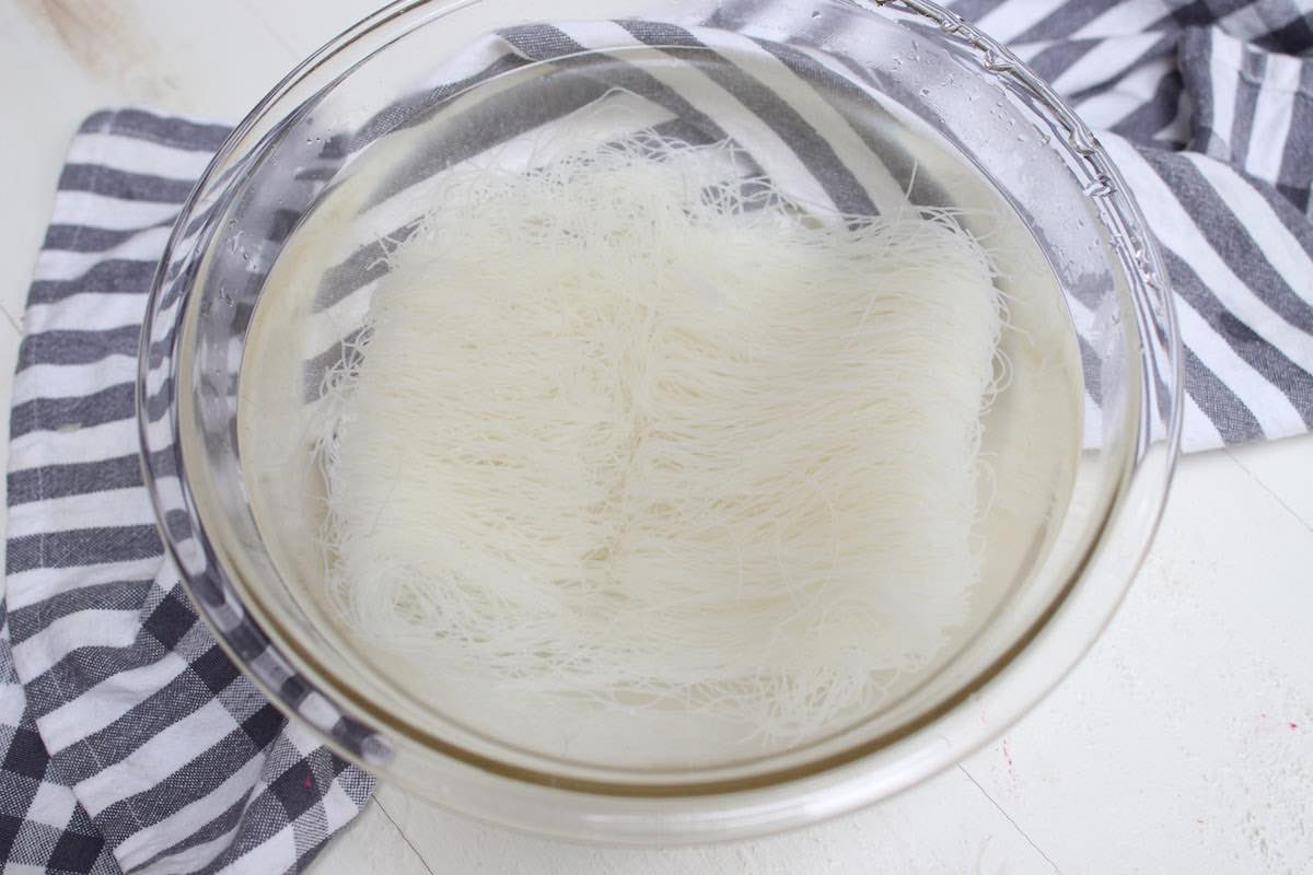 Soaking mei fun noodles in water to soften before stir frying