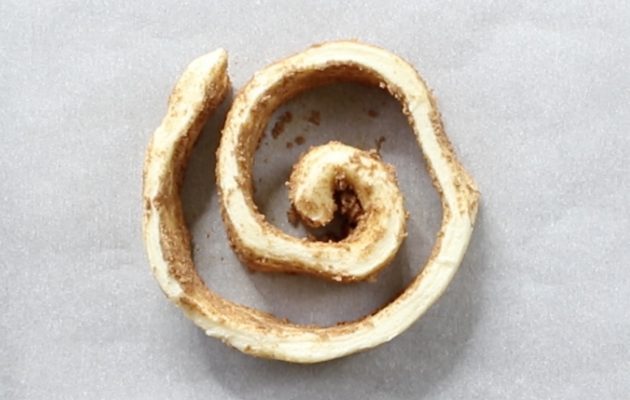 Unravelling cinnamon roll dough into a spiral pattern