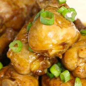 Coca Cola Chicken pan fried to tender and juicy perfection and drizzled with its own sweet and savory sauce on a serving plate, garnished with green onion for an easy party appetizer or dinner idea