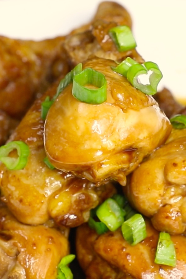 Coca Cola Chicken legs piled on a serving platter and garnished with minced green onion for a party