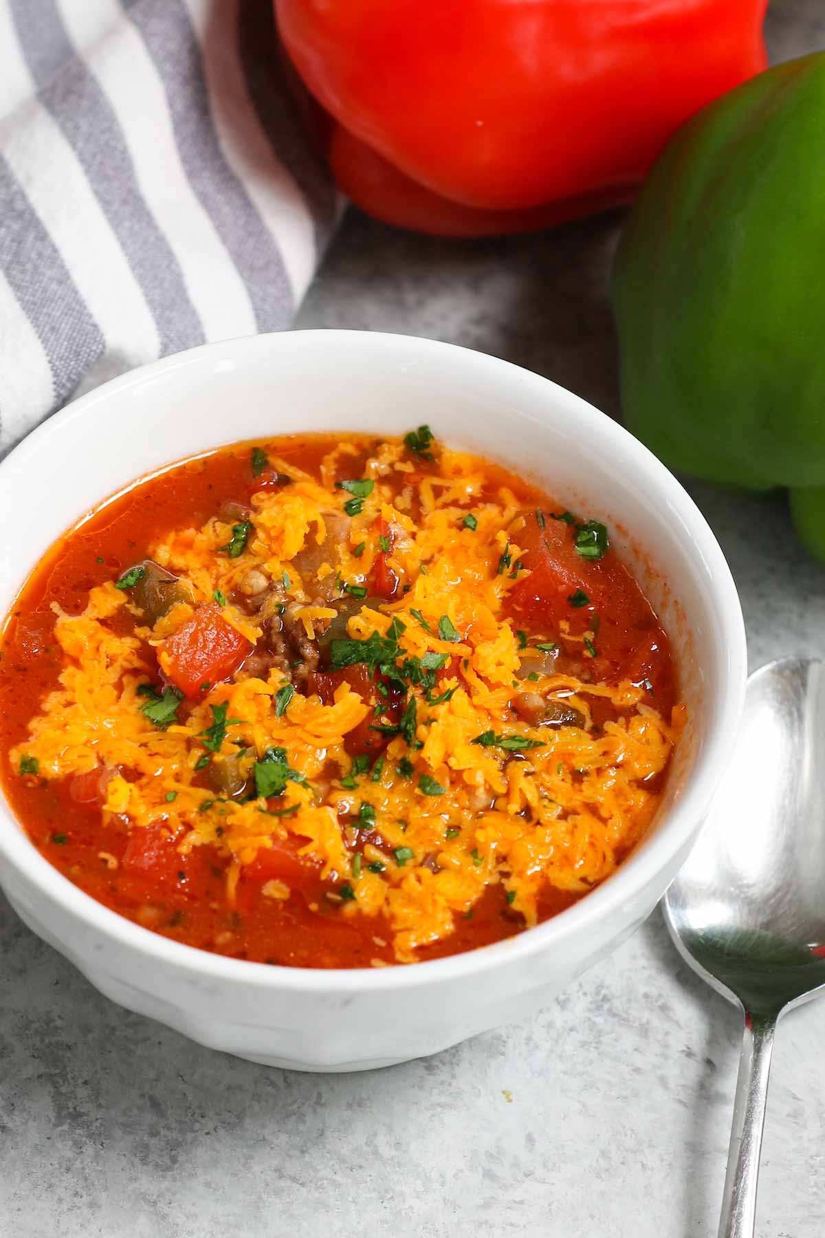 Crockpot stuffed pepper soup topped with shredded cheddar cheese and fresh parsley