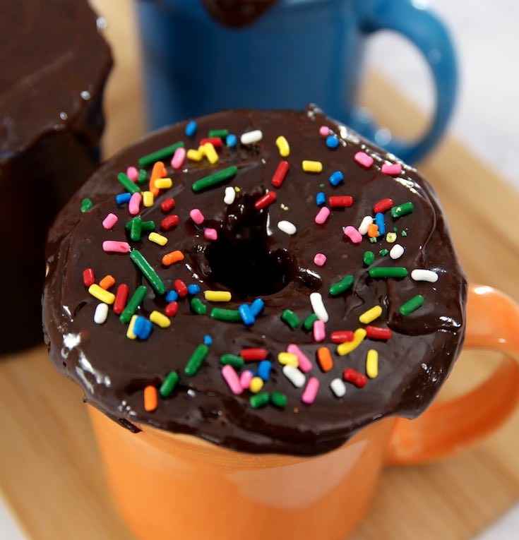 5 Minute Donut Mug Cake – A creamy, fluffy, delicious cake in a mug, ready in 5 minutes. It only requires a few simple ingredients: flour, sugar, baking powder, oil, milk, vanilla, chocolate chips, cream and nutmeg. So good and easy to make for the perfect dessert or snack. No bake. Vegetarian. Video recipe. | tipbuzz.com