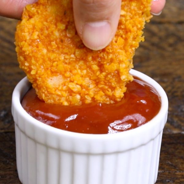 Dipping a fried mac and cheese bite into ketchup