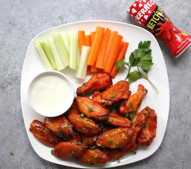 A plate of delicious game day wings with carrot and celery sticks