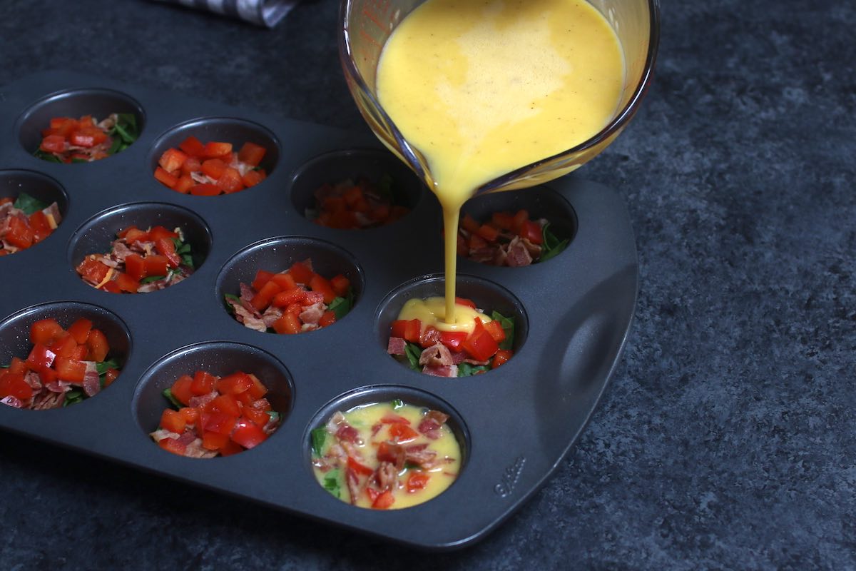 Pouring the egg mixture into each muffin tin.