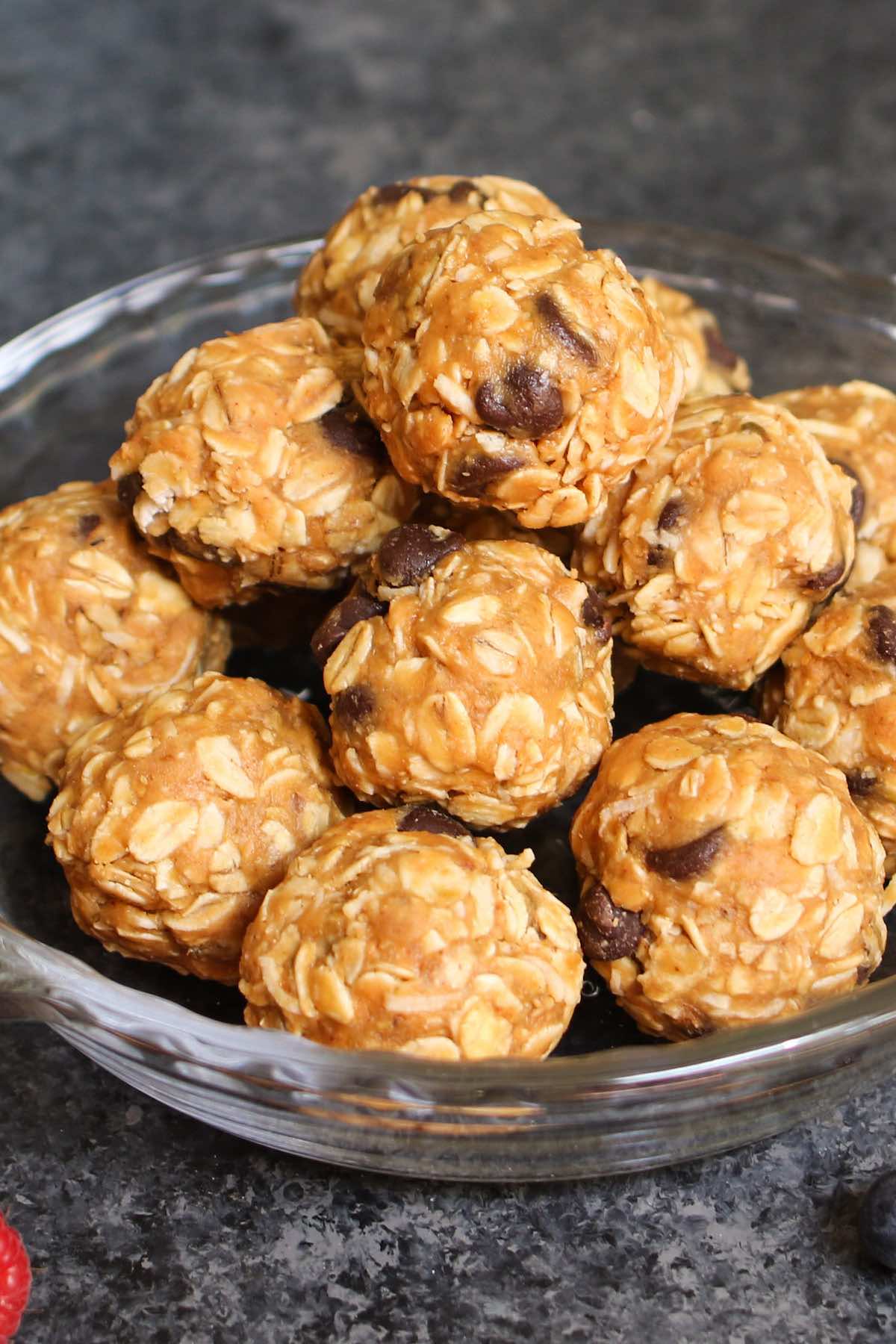 No Bake Energy Bites in a serving bowl showing off their ingredients: rolled oats, peanut butter, coconut and chocolate chips