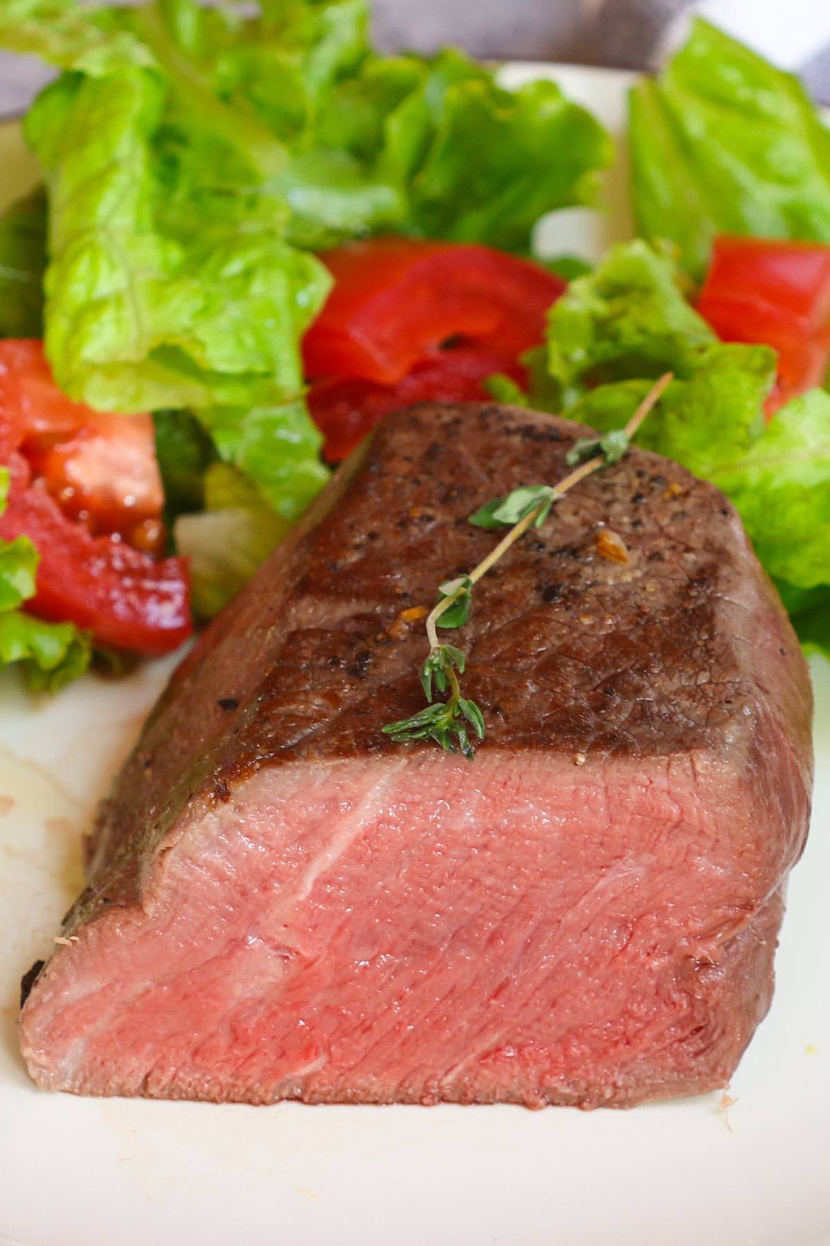 Cross-sectional view of a tenderloin steak cooked medium with a warm pink center