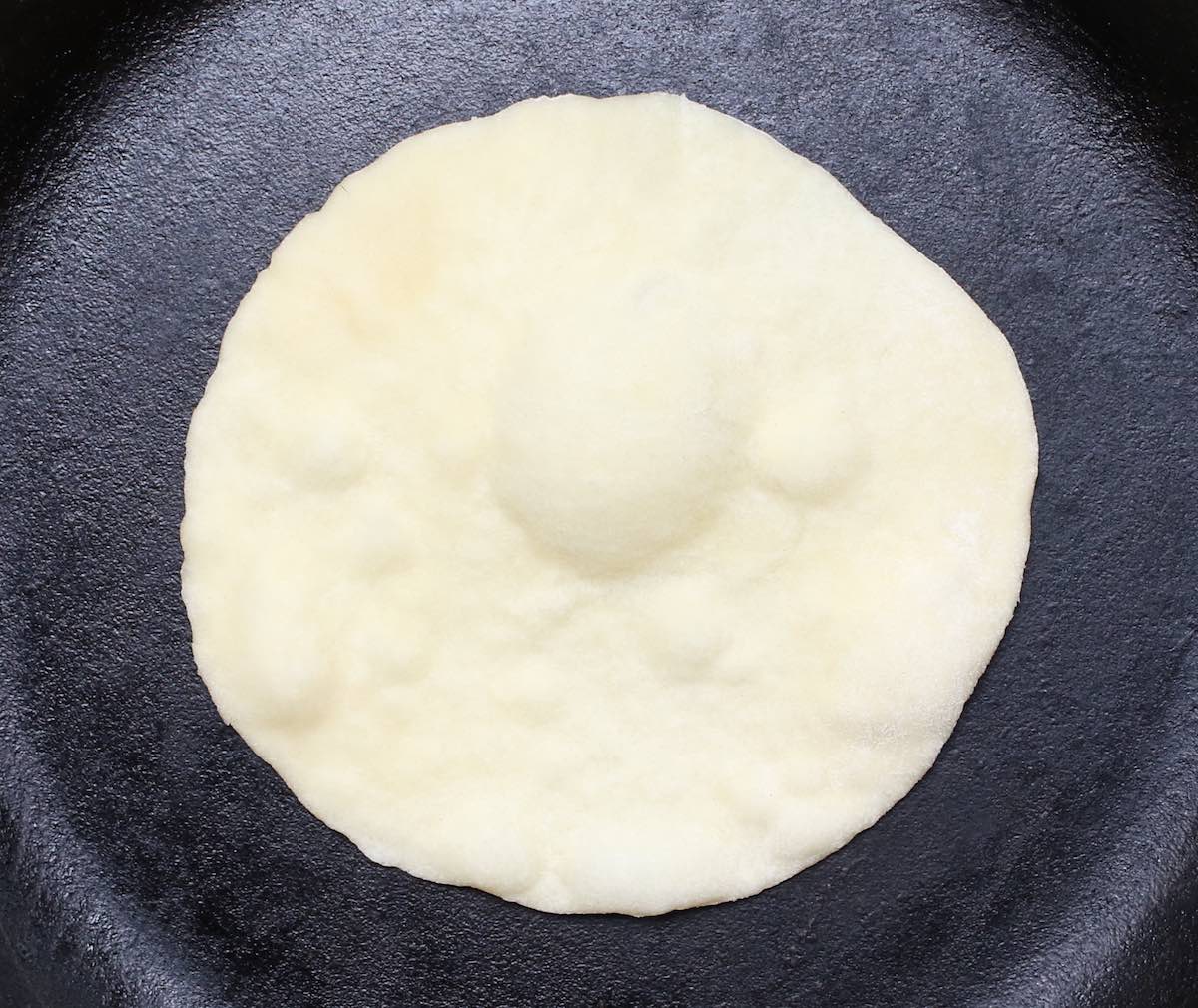 Flour Tortillas are puffed up in a hot skillet