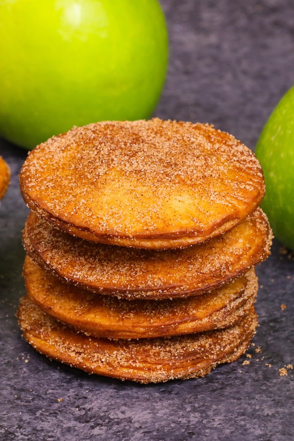 A stack of deep fried pastries dusted in cinnamon sugar