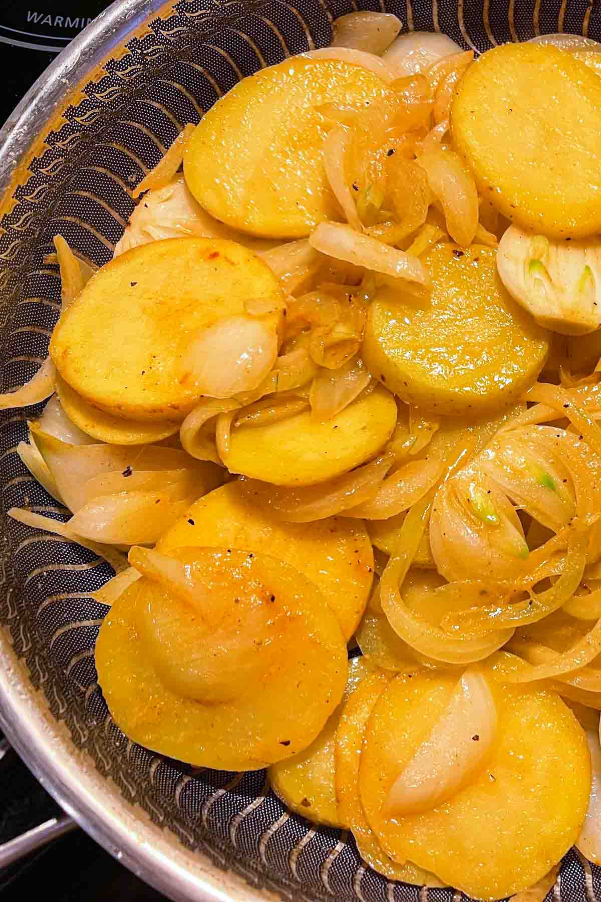 Fried potatoes and onions in a skillet after cooking