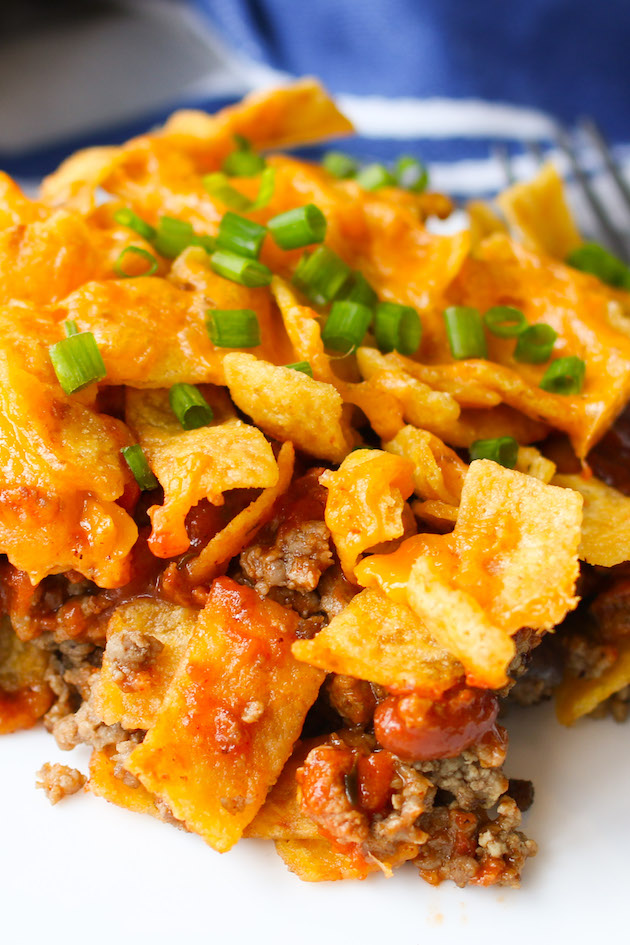 Frito Chili Pie is a Tex Mex classic featuring Fritos, beef chili and melted cheddar cheese on top. The perfect weeknight dinner that works equally well for Game Day, parties and get-togethers