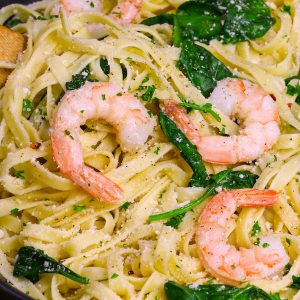 This Garlic Butter Shrimp Pasta is a simple and incredibly delicious one pot meal you can make in under 30 minutes. Tender and juicy shrimp are cooked in a garlicky and buttery sauce before being tossed with baby spinach and freshly grated parmesan. It’s a quick and easy dish that’s restaurant quality. #ShrimpPasta
