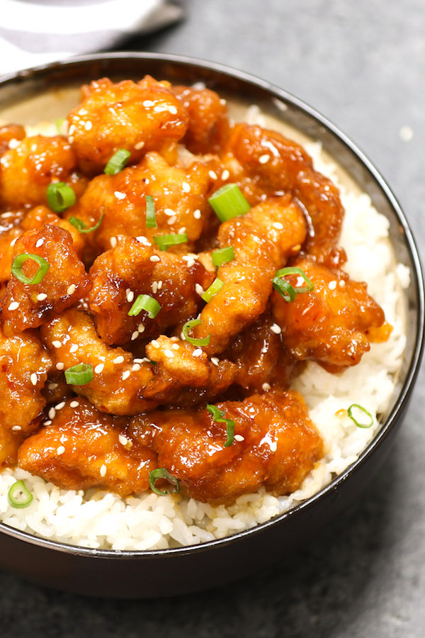 General Tso's Chicken - an overhead view of a delicious serving of General Tso Chicken in a bowl with rice, green onions and sesame seeds